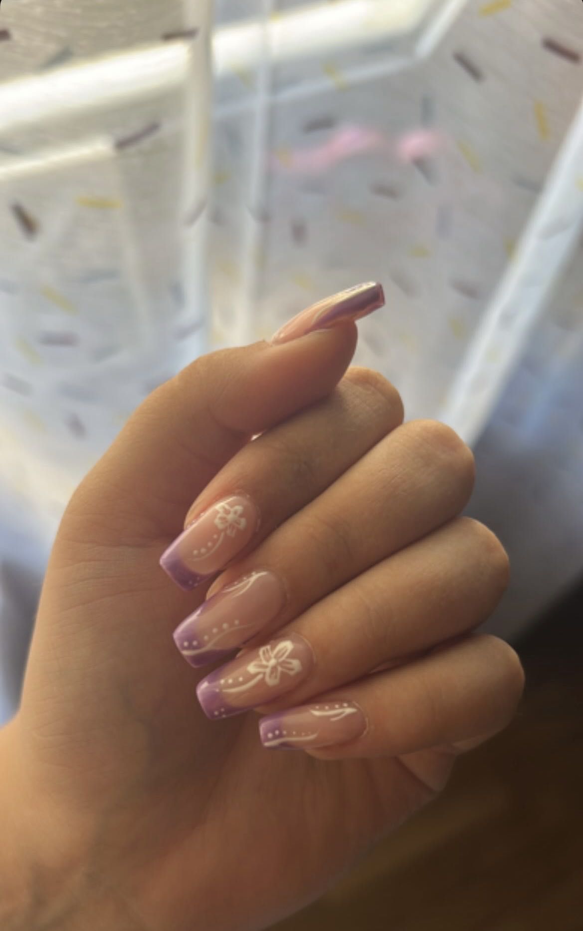 Manicure nude com decoração floral delicada, trabalho BM Beauty Studio